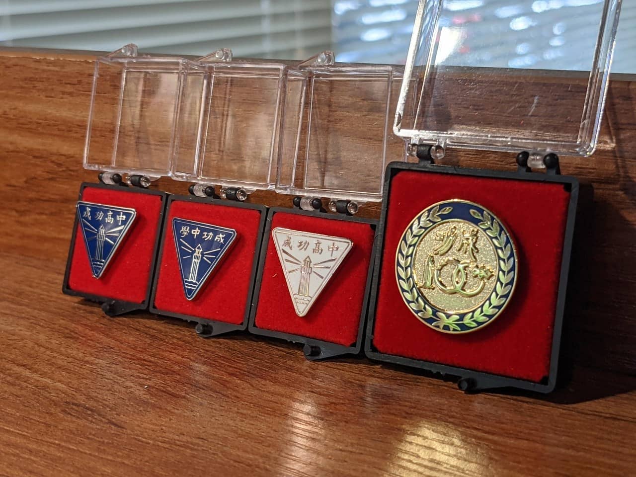 由左至右：成功高中現役校徽、成功中學時期校徽、成功高中現役校徽(玫瑰金特別版)、百週年校慶紀念章。